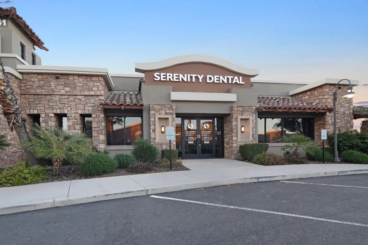 Serenity Dental storefront with stone exterior, landscaping, and entrance doors in daylight.